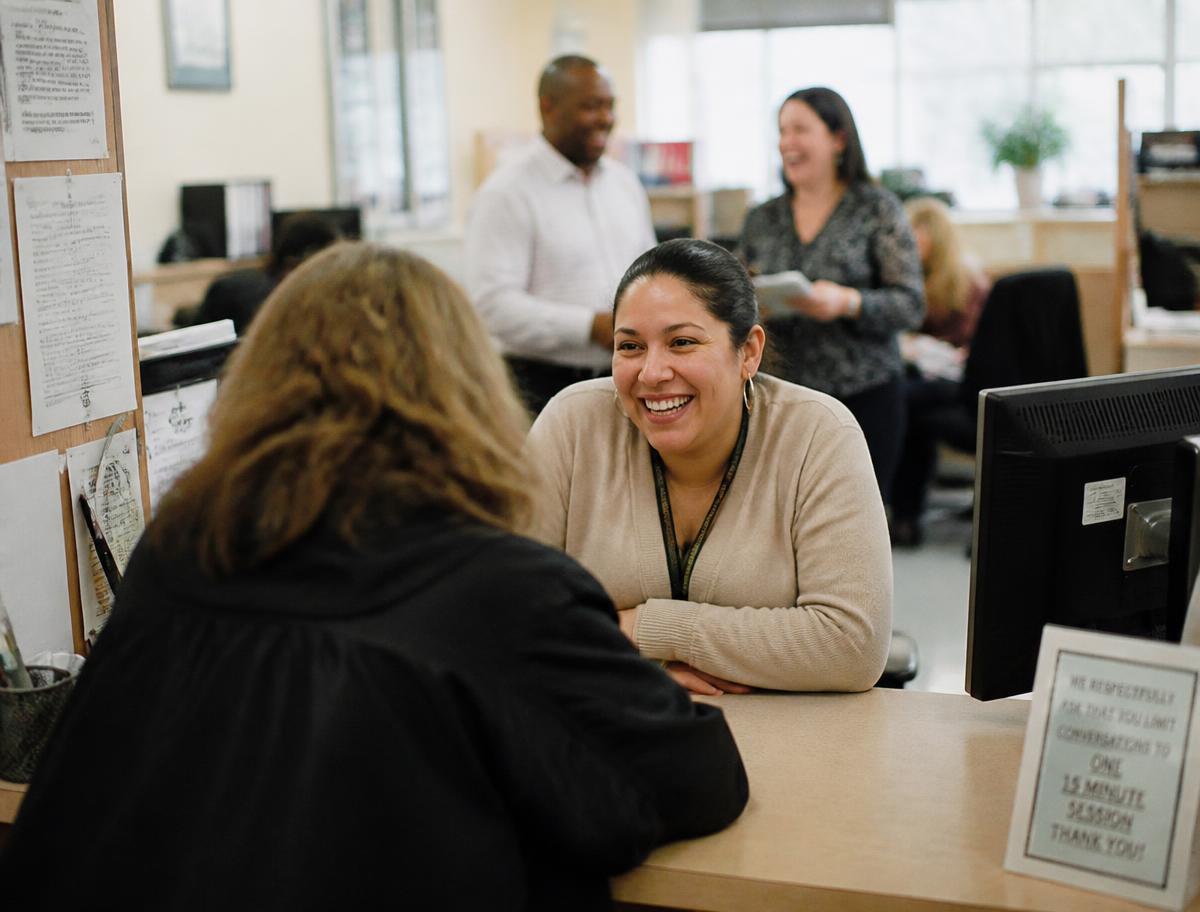 County staff working with a resident at a service counter